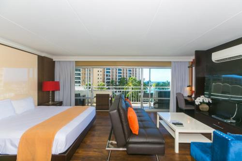 a hotel room with a bed and a balcony at Ilikai Tower 420 Lagoon View 1BR in Honolulu