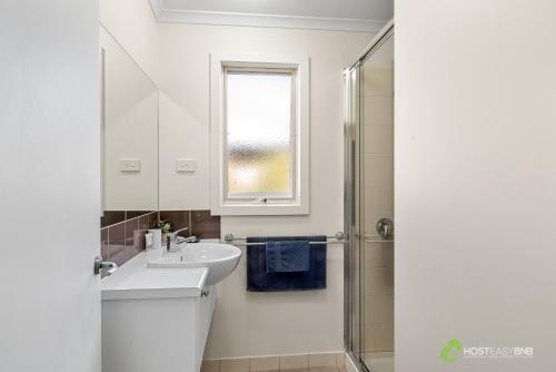 La salle de bains blanche est pourvue d'un lavabo et d'une douche. dans l'établissement Rural 5 Star Villa's with Resort Amenities, à Cowes