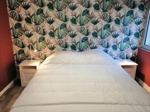 een slaapkamer met een bed met bloemenbehang bij Beautiful apartment by the harbor in Port-en-Bessin-Huppain in Port-en-Bessin-Huppain