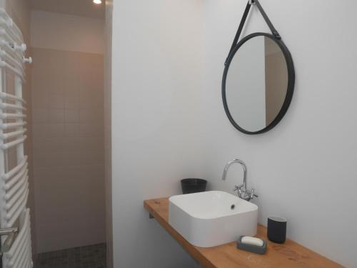 ein Badezimmer mit einem weißen Waschbecken und einem Spiegel in der Unterkunft Beachfront Holiday Home, Penmarch-St Guénolé in Penmarcʼh