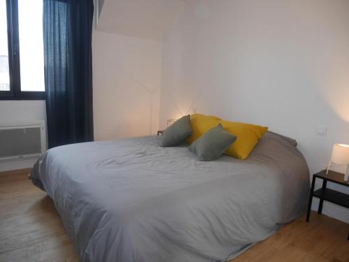 une chambre avec un lit avec deux oreillers dessus dans l'établissement Apartment in Penmarch near Sandy Beach, à Penmarcʼh