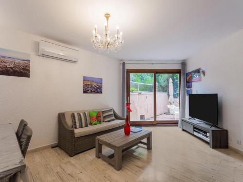 ein Wohnzimmer mit einem Sofa und einem TV in der Unterkunft Elegant holiday home with pool in Toulon