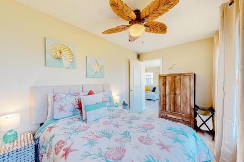 a bedroom with a bed and a ceiling fan at Surf Club A-5 in Dauphin Island