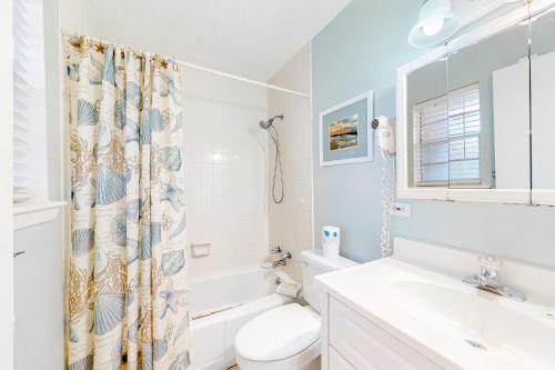 a bathroom with a toilet sink and a shower curtain at Surf Club A-5 in Dauphin Island