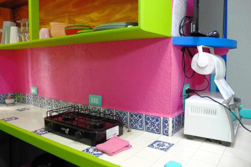 a toy kitchen with a pink and green wall at Beautiful & Cozy Studio in Akumal Paradise-Wifi, AC in Akumal