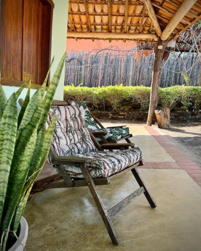 a patio with two chairs and a potted plant at Pousada Canto Feliz in Serra do Cipo