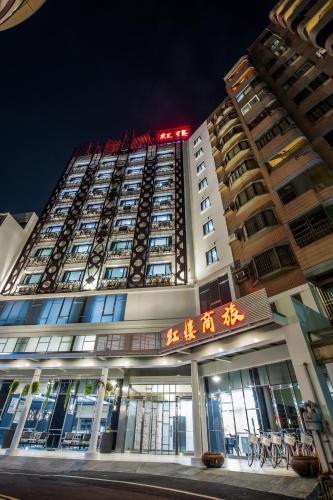 a tall building with chinese writing on it at night at Red hotel in Yuanlin