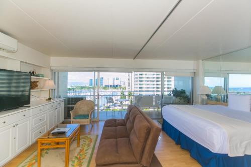 een slaapkamer met een groot bed en een televisie bij Ilikai Tower 839 Yacht Harbor View 1BR in Honolulu