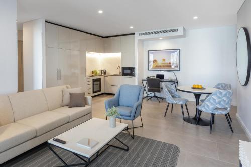 a living room with a couch and chairs and a table at Meriton Suites Surfers Paradise in Gold Coast