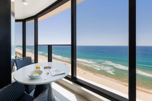 a table in a room with a view of the beach at Meriton Suites Surfers Paradise in Gold Coast