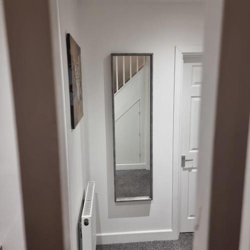 La salle de bains est pourvue d'un miroir et d'une porte blanche. dans l'établissement 4 bed apartment In Enfield north London, à Enfield Lock