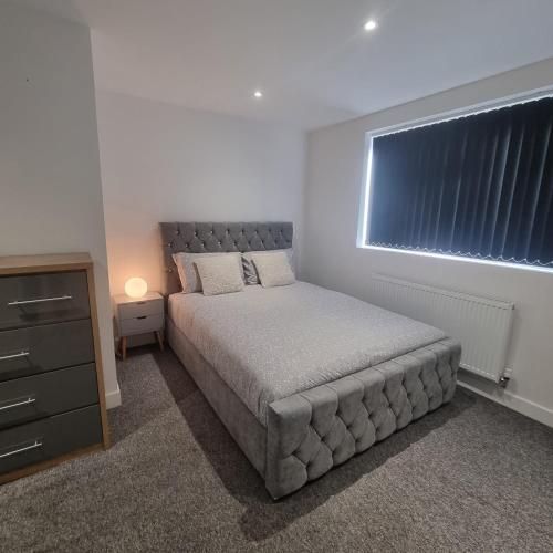 Enfield Lock的住宿－4 bed apartment In Enfield north London，一间卧室设有一张大床和一个窗户。