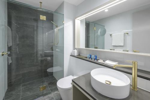 a bathroom with a sink and a glass shower at Meriton Suites Surfers Paradise in Gold Coast