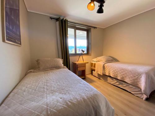 1 dormitorio con 2 camas y ventana en Depto al lado de la Playa en el Centro de Pucón, en Pucón