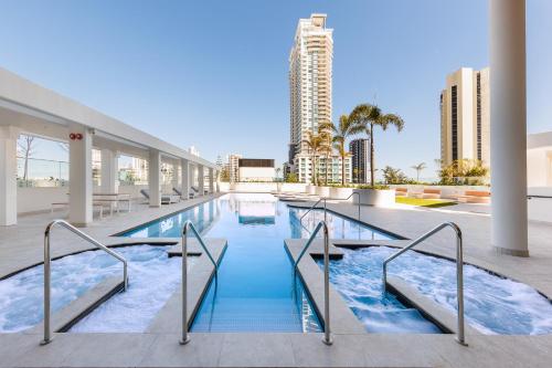 a swimming pool in a building with buildings in the background at Meriton Suites Surfers Paradise in Gold Coast