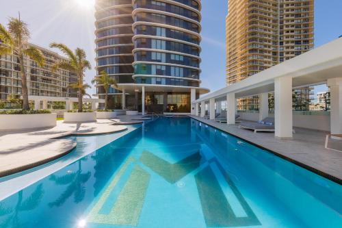 a swimming pool with two tall buildings at Meriton Suites Surfers Paradise in Gold Coast