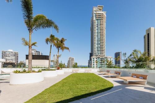 a park with benches and palm trees in a city at Meriton Suites Surfers Paradise in Gold Coast