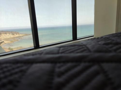 a bed in a bedroom with a view of the ocean at Departamento Suite frente al mar Poseidon Manta in Manta