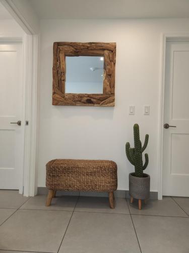 a room with a chair and a mirror and a cactus at ARUBA DREAM GETAWAY 2BR/2BT OCEAN & POOL VIEW in Oranjestad