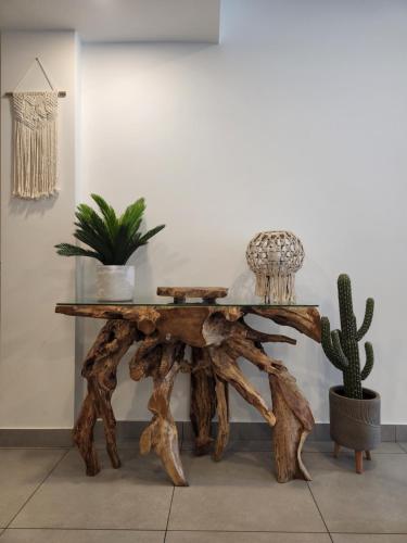 a table made out of logs with a cactus at ARUBA DREAM GETAWAY 2BR/2BT OCEAN & POOL VIEW in Oranjestad
