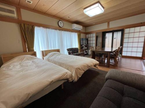 a hotel room with two beds and a dining room at 草津温泉 湯之風 in Kusatsu