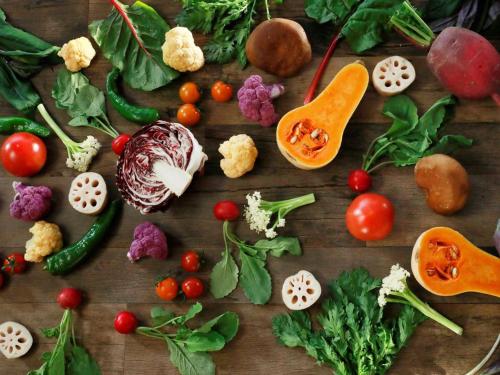a bunch of vegetables on a wooden table at the square hotel KANAZAWA in Kanazawa