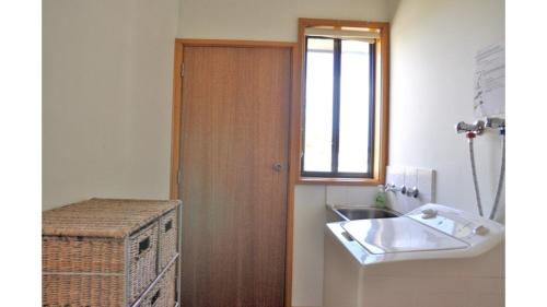 een badkamer met een wastafel, een spiegel en een raam bij Family Retreat on Anderson in Inverloch
