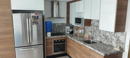 a small kitchen with a refrigerator and a sink at Departamento Suite frente al mar Poseidon Manta in Manta
