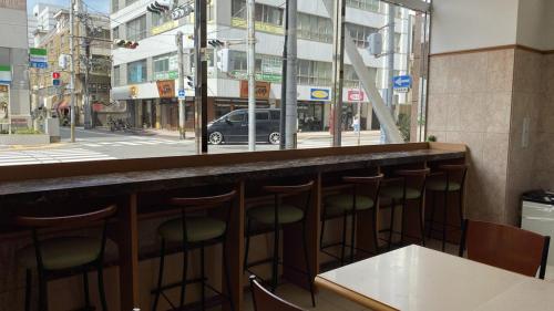 a bar with a row of stools in front of a window at Toyoko Inn Oita Ekimae in Oita