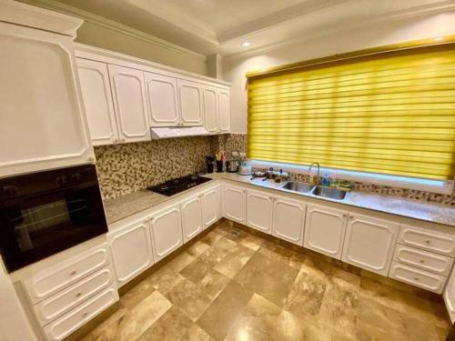 a kitchen with white cabinets and a window with a sink at Big & Elegant w/Nice Location nr SM &Ateneo Matina in Davao City