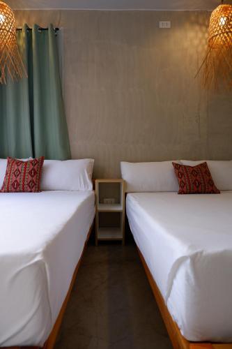 two beds sitting next to each other in a room at Lubihan Siargao in General Luna