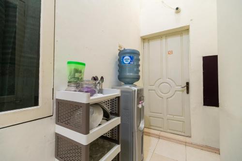 a small refrigerator in a room next to a door at RedDoorz Syariah near Pasar Aur Kuning in Bukittinggi