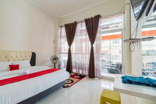 a bedroom with a bed and a large window at RedDoorz Syariah near Pasar Aur Kuning in Bukittinggi