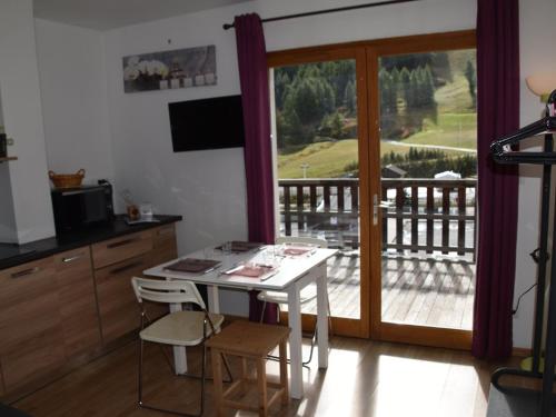 Il dispose d'un balcon et d'une cuisine avec une table et des chaises. dans l'établissement Studio avec grande terrasse face aux pistes, plein sud, animaux acceptés - FR-1-266-196, à Montgenèvre