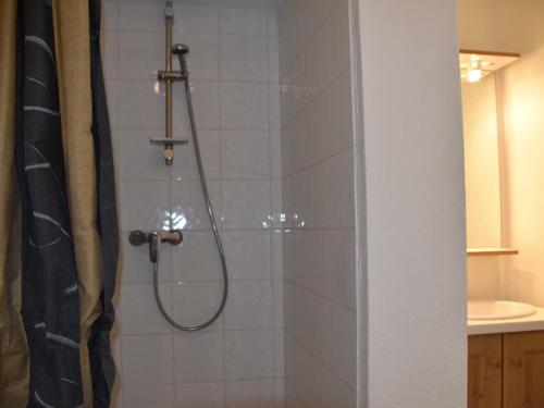 une salle de bain avec une douche avec un rideau de douche dans l'établissement Studio avec grande terrasse face aux pistes, plein sud, animaux acceptés - FR-1-266-196, à Montgenèvre