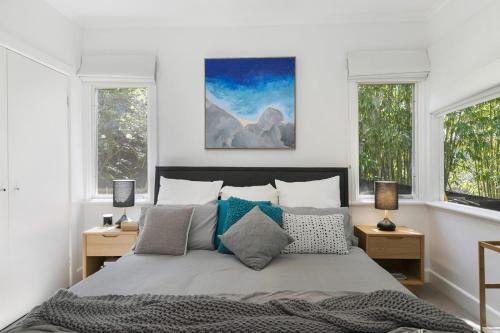 a bedroom with a large bed with two windows at Whitecaps in Lorne