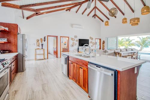 a kitchen with white walls and wooden cabinets at Tres Palmas Beach House in Maya Beach
