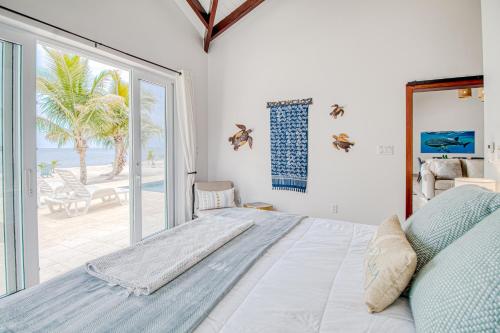 1 dormitorio con cama y vistas a la playa en Tres Palmas Beach House, en Maya Beach