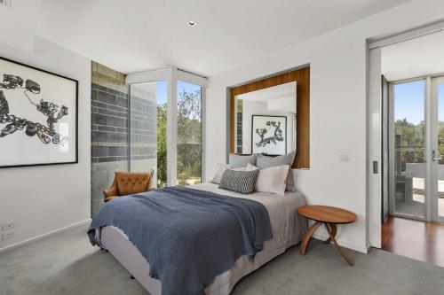 una camera con letto, tavolo e finestre di Windform House a Moggs Creek