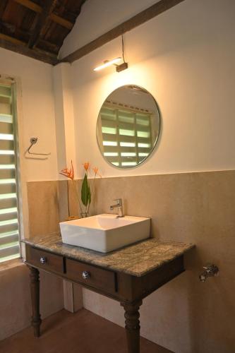 un baño con lavabo y espejo en Pool Villa - The Humming Trees, Pala, en Lālam