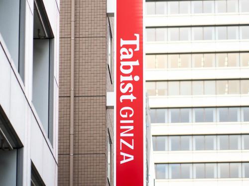 a red sign on the side of a building at Tabist Ginza in Tokyo