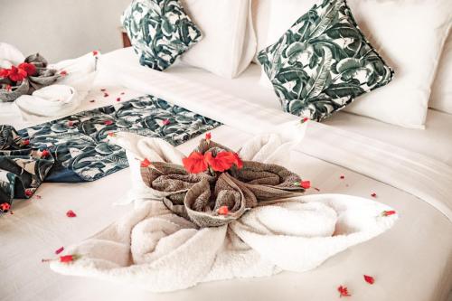 a bed with a towel on it with pillows at Segara Lombok Beach Resort in Selong Belanak