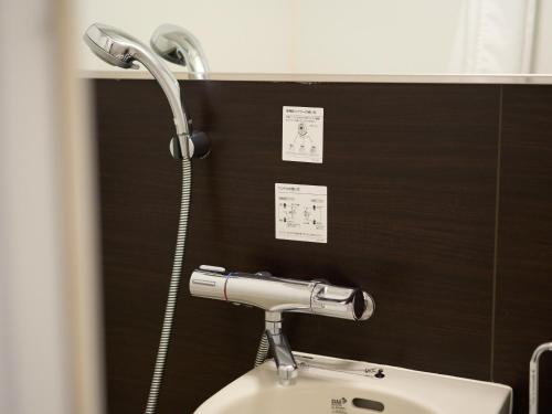 a shower over a toilet in a bathroom at Tabist Ginza in Tokyo