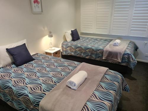 a room with two beds with towels on them at Wharf Lodge River View Apartment in Maroochydore