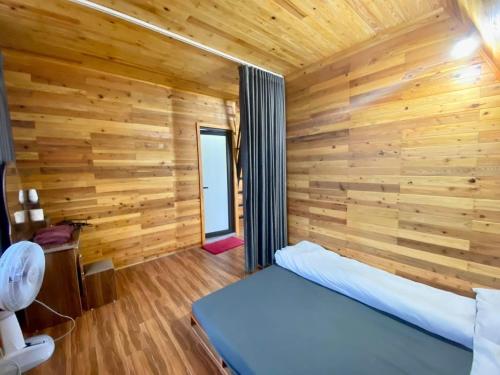 a bedroom with wooden walls and a bed in a room at Sunrise Villa - Venue Travel in Vĩnh Phúc