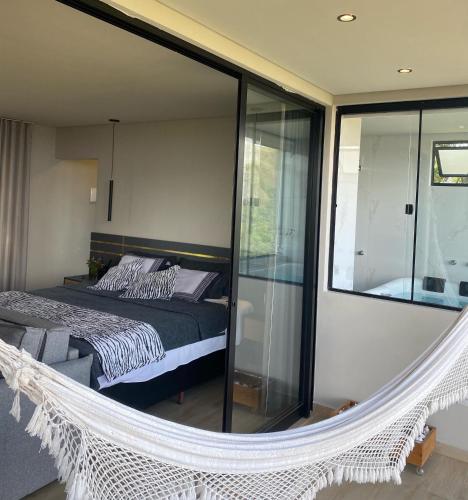 a bedroom with a balcony with a bed and a mirror at Loft Paraíso Da Serra in Congonhas