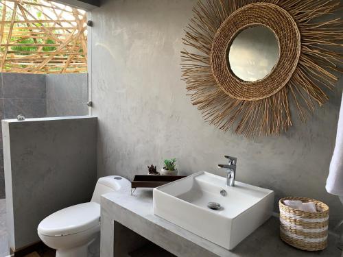 uma casa de banho com um lavatório, um WC e um espelho. em IslaVerde Hotel em La Mesa