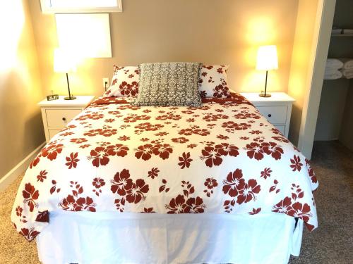 a bedroom with a bed with a floral bedspread at The Lodge Dog and Family Friendly 5 Bedrooms 13 guests 10 beds in Saint Peter