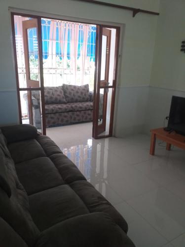 a living room with a couch and a television at Pool View Apartment in Camperdown