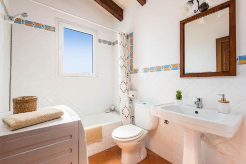 uma casa de banho com um lavatório, WC e um espelho. em Villa Vientosol by Villa Plus em Cala en Forcat